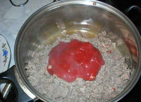 1. Этап. Суп чили с фасолью: 4. Кастрюлю, в которой будем варить суп, ставим на огонь. Наливаем в неё немного растительного масла, закидываем фарш. Обжариваем его, все время разминая вилкой. К готовому фаршу добавляем томатную пасту.