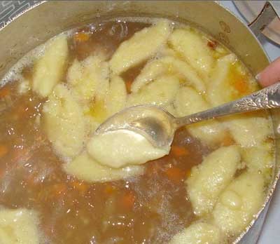 Суп с клёцками 1. Этап. Суп с клёцками: В воду добавьте картофель, посолите. Следом добавьте перец, варите пять минут. Добавьте лука и моркови, доведите до кипения. Чайной ложкой наберите немного теста и опустите в кипящий бульон. Добавьте перец, лавровый лист. Варите 5 минут.