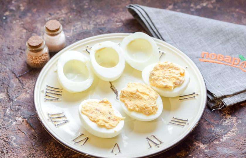 1. Этап. Фаршированные яйца на год Быка: Яйца разрежьте пополам. Наполните три белка приготовленной массой.