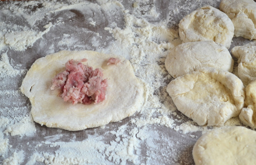 1. Этап. Беляши с мясом: Каждый кусок раскатайте по форме лепешки, положите в центр начинку, а края заверните и закрепите.