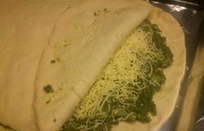 1. Этап. Закрытая пицца с брокколи: Для начинки обжарьте на сковороде репчатый лук и брокколи, добавьте немного воды и потушите еще 5-7 минут. Подошедшее тесто разделите пополам, каждую часть тонко раскатайте. Выложите один лист в форму (смазанную маслом), сформируйте бортики. Сверху распределите начинку из брокколи и лука. Присыпьте тертым сыром и накройте вторым листом теста. Аккуратно соедините края теста.