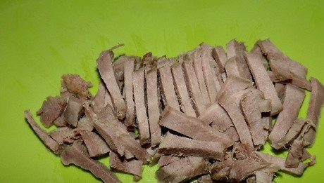 1. Этап. Салат из языка с грецкими орехами: 1. Язык, предварительно отварив и остудив, нарежьте тонкой соломкой.