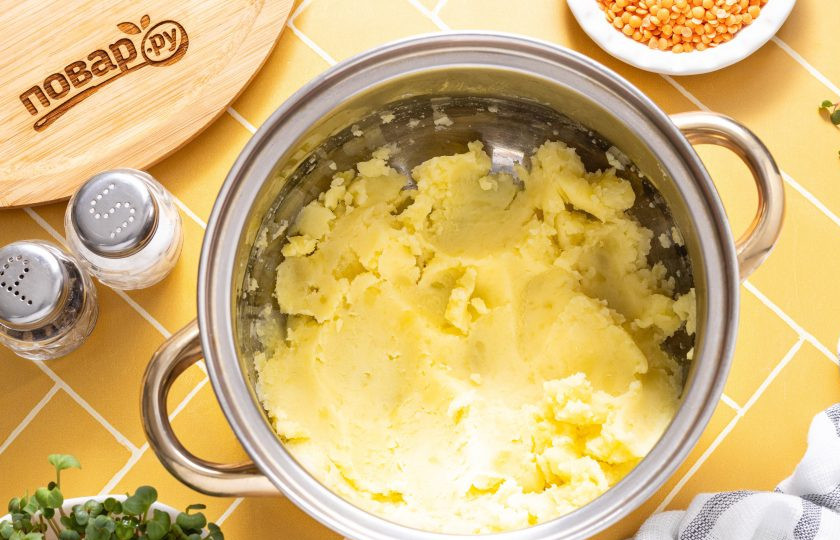 1. Этап. Пюре из картофеля и красной чечевицы: Слейте воду с вареного картофеля и разомните его в пюре толкушкой.