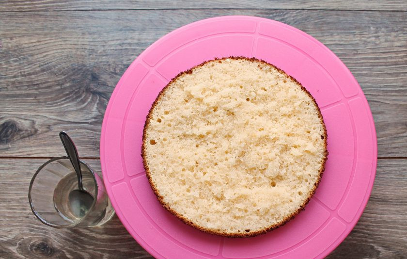 1. Этап. Торт Ириска с вареной сгущенкой: Бисквит разрежьте на две части, каждый пропитайте сиропом от консервированных фруктов.