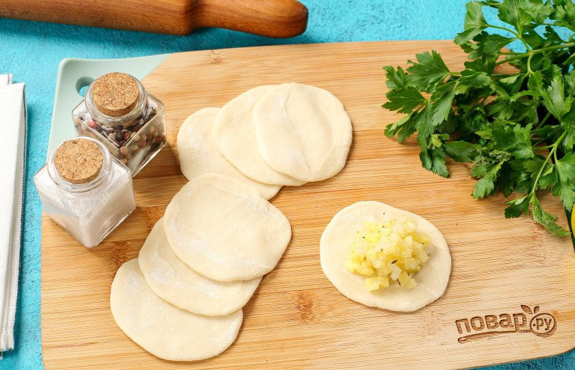 1. Этап. Вареники на пару: Каждый кусочек теста обваляйте с двух сторон в муке и раскатайте в форме круга. По центру каждого кружочка теста выложите начинку. Так как начинка от соли пустит в процессе сок, её необходимо время от времени перемешивать.