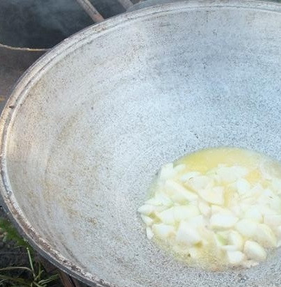 1. Этап. Курица в казане: Растопите в казане сливочное и растительное масло. Добавьте крупно нарезанный лук. Обжаривать до прозрачности.