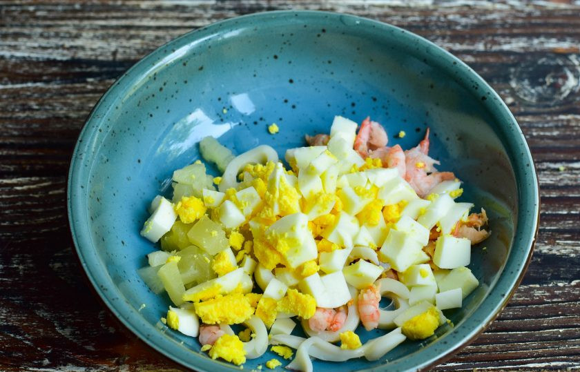 1. Этап. Салат с кальмарами, креветками и ананасами: Выложите все нарезанные ингредиенты в миску.