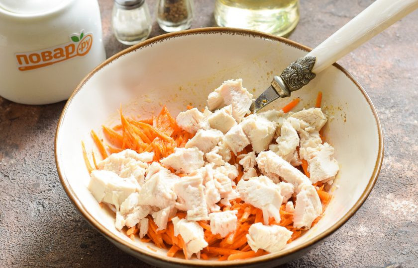 1. Этап. Салат с корейской морковью и маринованными огурцами: Вареное куриное филе нарежьте небольшими кубиками и добавьте к моркови.