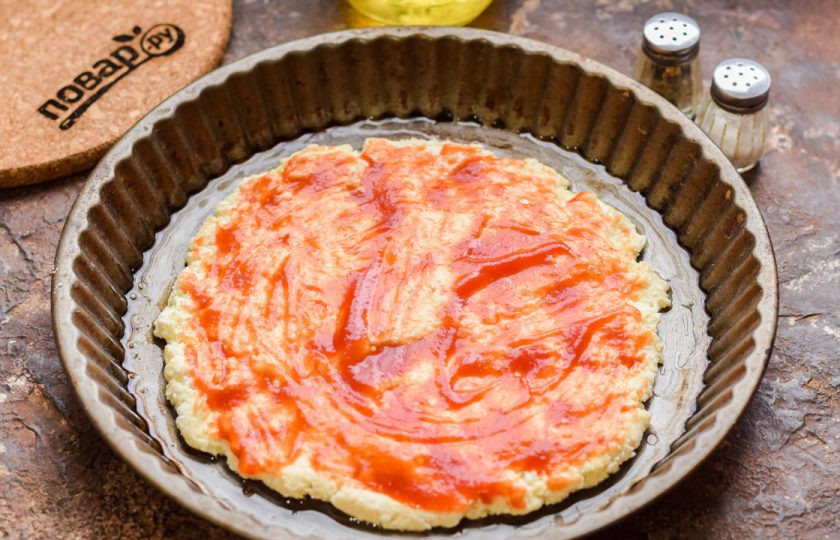 1. Этап. ПП пицца на творожном тесте: Смажьте основу томатным соусом.