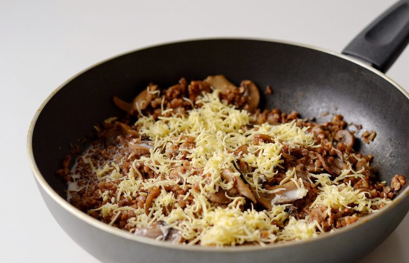 1. Этап. Гречотто с грибами: Когда бульон впитается в крупу, добавьте вино. Затем, когда вино выпарится, добавьте подогретые сливки. Перемешайте. И сразу добавьте мелко натёртый сыр. Потушите все вместе, пока сыр не расплавится.