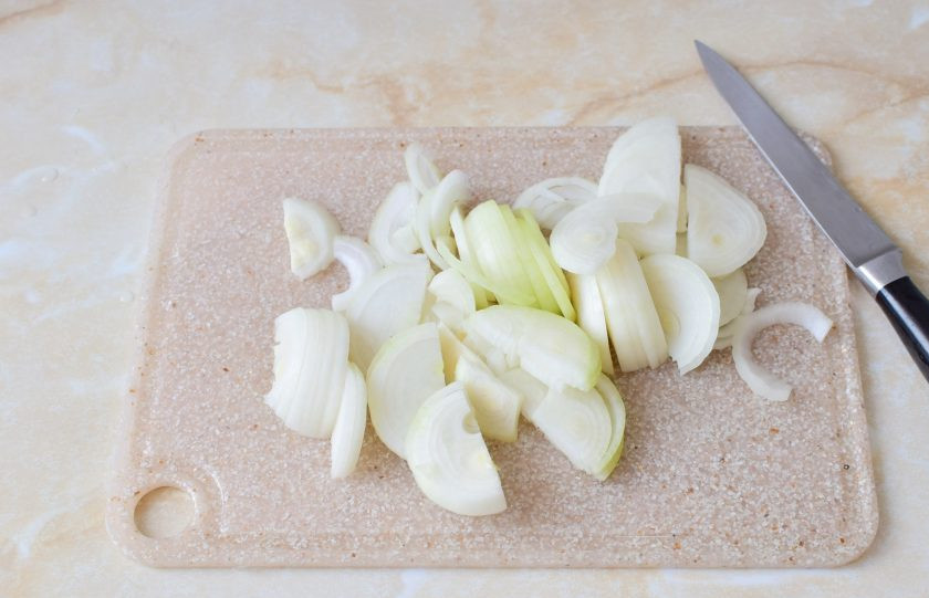 1. Этап. Шампиньоны с луком: Лук очистите от шелухи и ополосните в холодной воде. Нарежьте лук полукольцами.