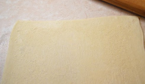 1. Этап. Берлинское печенье: 1.Слоеное тесто выложите на рабочую поверхность, присыпанную мукой, и раскатайте немного. Очень тонким тесто делать не стоит, достаточно средней толщины.