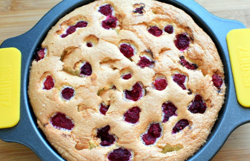 1. Этап. Меренговая шарлотка с малиной и белым шоколадом: Перелейте тесто в подготовленную форму и выложите сверху ягоды малины. Пеките в прогретой духовке около получаса. Поверхность шарлотки пойдет трещинками и корочка станет хрупкой.