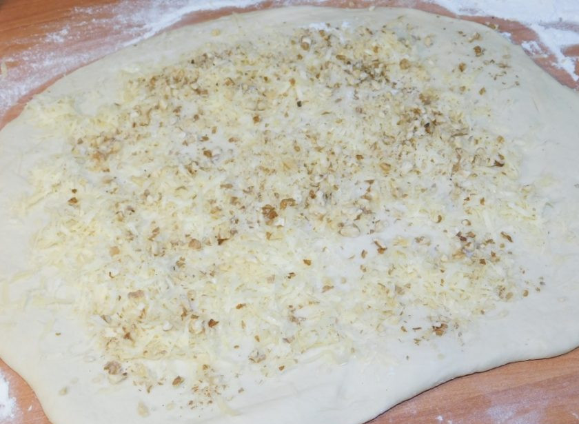 1. Этап. Белый хлеб с сыром и орехами: Готовое тесто раскатайте, посыпьте тертым сыром и измельченными орехами.