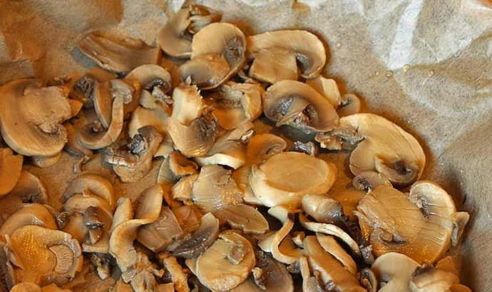 1. Этап. Слоеный пирог-перевертыш: Форму для выпечки застилаем пергаментом, выкладываем слой грибов.