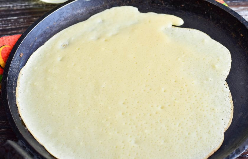 1. Этап. Блины на йогурте с дырочками: На разогретую сковороду налейте тесто. Нагибайте сковороду и крутите до тех пор, пока тесто по ней полностью не разбежится.