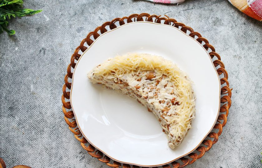 1. Этап. Салат Арбузная долька с курицей и грибами: Оставшимся сыром закройте дугообразную часть дольки и немного по краю сверху.