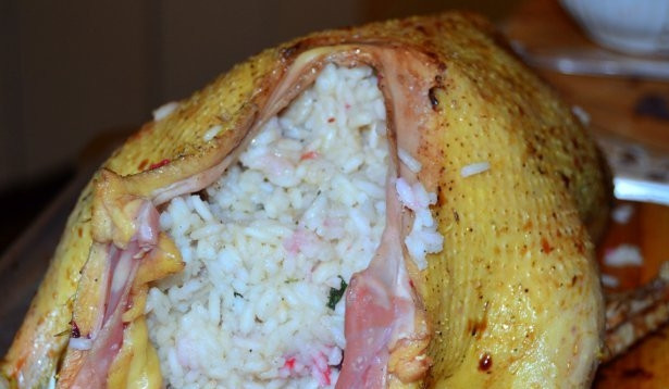 1. Этап. Утка с розмарином: Теперь начините утку кашей, все края закрепите зубочистками или нитками. Полейте оставшимся соусом. Засуньте тушку в рукав для запекания, добавьте немного нерастёртого розмарина.