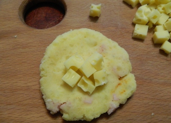 1. Этап. Картофельные шарики с ветчиной и сыром: 5. Хорошо перемешиваем все до однородности. Затем берем немного теста и делаем из него лепешку. В середину кладем несколько кусочков сыра.