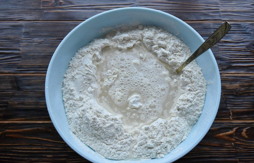 1. Этап. Табасаранское чуду: В первую очередь просейте муку через сито в миску соответвующего размера. В центре сделайте углубление, раздвинув муку к краям посуды. В теплой воде размешайте половину нормы соли и влейте в углубление в муке.