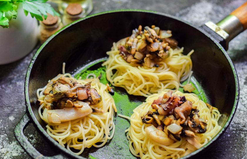 1. Этап. Гнезда с морепродуктами: Поверх гнезд выложите морепродукты и грибы со сковороды.