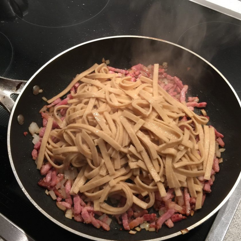 1. Этап. Спагетти с соусом Карбонара: 6. Выложите макароны из кастрюли в дуршлаг, а затем сразу же отправьте на сковороду к луку и бекону.