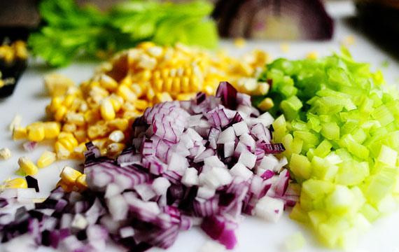 1. Этап. Куриный салат с сыром фета и кукурузой: Очень острым ножом отделить зерна от кукурузных початков. Смешать кукурузные зерна с луком и сельдереем. Отложить в сторону.