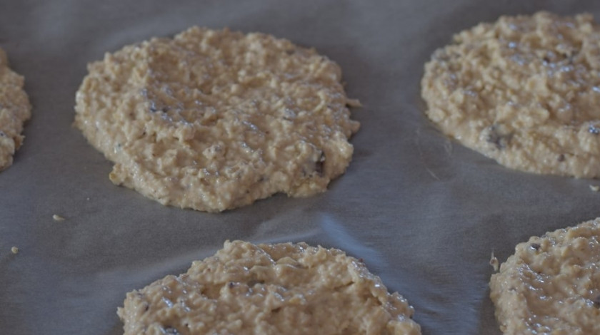 1. Этап. Овсяное печенье с медом на кефире: На противень, застланный пергаментом, влейте тесто в виде лепёшек.