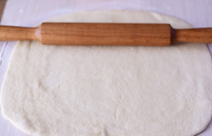 1. Этап. Осенние булочки: Рабочую поверхность припылите небольшим количеством муки, выложите тесто, раскатайте его в прямоугольный пласт толщиной примерно в 0.7-1 см. Для удобства в работе я всю массу теста поделила на две части.