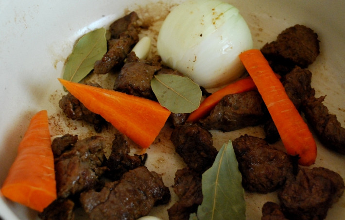 1. Этап. Тушеная телятина с грибами: Возвращаем мясо в чистый сухой сотейник, добавляем к нему стебель лука-порей, очищенную половинку луковицы, нарезанную на несколько частей морковь (тоже очищенную), чеснок, лавровый лист и гвоздику.