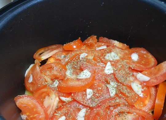 1. Этап. Свинина с помидорами и картофелем в мультиварке: 5. Вымыть и просушить помидоры. При желании можно снять с них кожицу. Нарезать тонкими кружочками и выложить сверху. Очистить чеснок и нарезать небольшими кусочками. Сверху помидоры присыпать солью, перцем, приправами по вкусу.