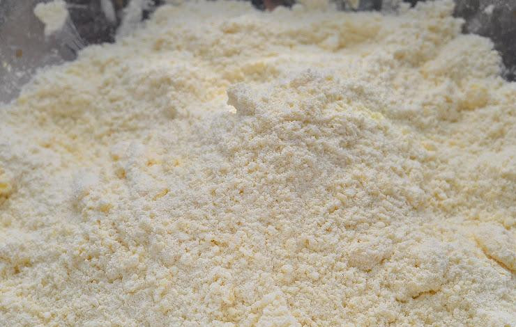 1. Этап. Яблочные сконы: Добавляем к мучной смеси сахар, а затем перетираем всю эту смесь до консистенции крошки.