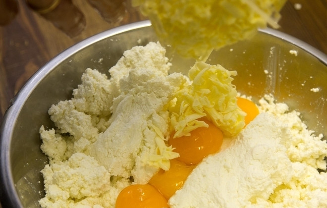 1. Этап. Пельмени с творогом: 4. Сливочное масло натрите на терке и добавьте к творогу, а также положите щепотку соли и сахарный песок.