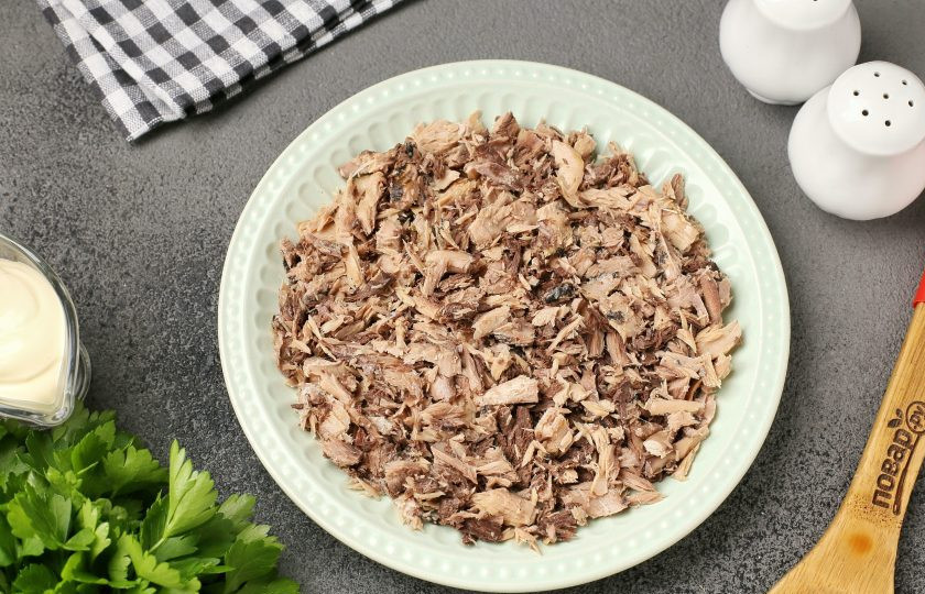 1. Этап. Слоёный салат с тунцом, помидорами, сыром и яйцами: Салат можно сформировать при помощи кулинарного кольца или просто выложить слоями на плоскую тарелку. Первым слоем выложите консервированную рыбу, разобранную на небольшие кусочки. Смажьте слой майонезом.