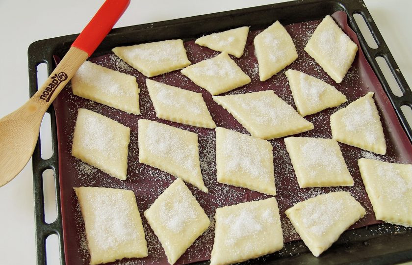 1. Этап. Слоеное печенье на сметане: Переложите заготовки из теста на противень, смажьте верх взбитым белком и посыпьте обильно сахаром. Выпекайте при 180 градусах около 20-30 минут.