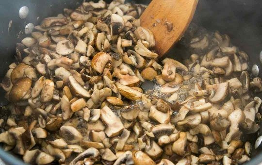 1. Этап. Лазанья простая: В большом сотейнике начните жарить грибы, порезанные дольками. Добавьте немного соли. Масло не нужно. Когда грибы станут выделять жидкость, добавьте измельченный лук.