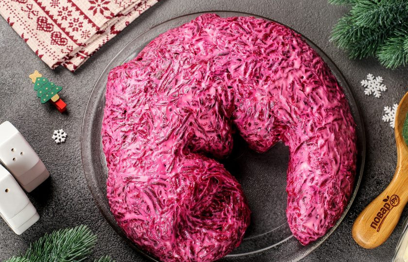 1. Этап. Селедка под шубой на год Дракона: Последний слой — тертая на крупной терке свекла. Свеклу распределите не только сверху, но и со всех сторон. Посолите и смажьте майонезом, а затем при помощи ложки или небольшой лопатки придайте окончательную форму. Не забудьте сделать углубление на мордочке для будущих глаз.