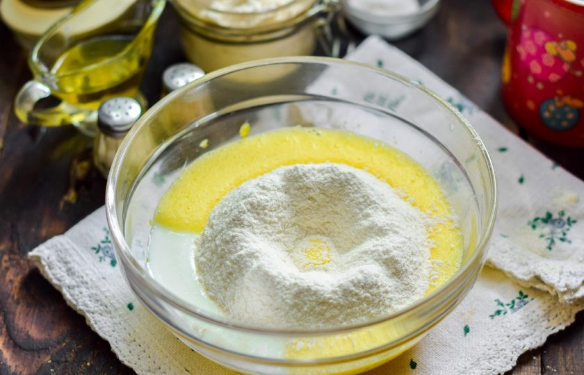 1. Этап. Вкусные и пышные оладушки: Просеивайте частями пшеничную муку, замешивая тесто миксером или венчиком.
