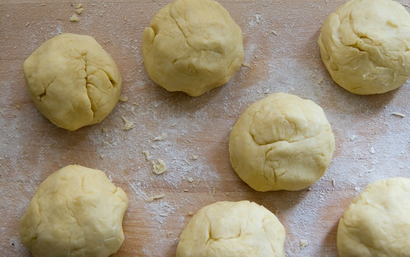 1. Этап. Торт Микадо: Добавляем просеянную муку с разрыхлителем. Перемешайте и замесите тесто. Раскатайте тесто и разделите его на 7 частей, каждую часть скатайте в шар и поместите в холодильник под пленку на 1 час.