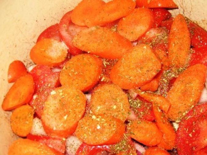 1. Этап. Дамлама из баранины: Крупно порежьте помидоры крупными кусочками, а морковь кружками. Выложите слой из половины помидоров, затем всю морковь. Снова посолите, поперчите и посыпьте немного приправой.