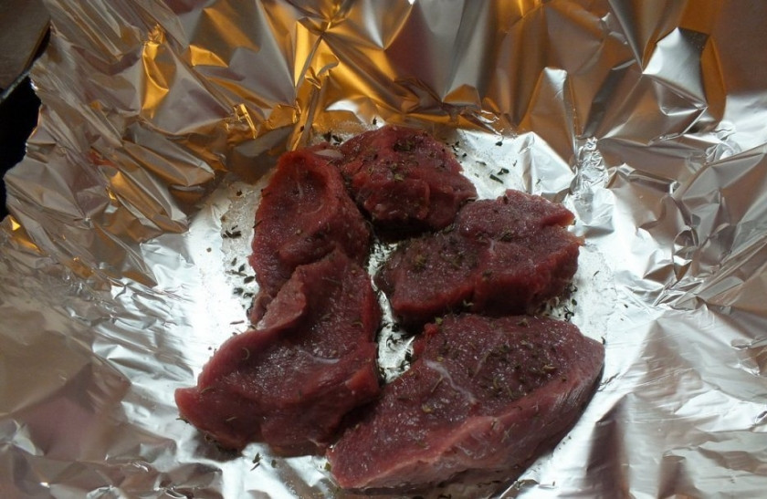 1. Этап. Говядина под шубой: 1. Фольгу расстилаем на сковородке, чуть смажем растопленным маслом. Выкладываем говядину, порезанную кусочками. Солим, перчим, посыпаем приправами.