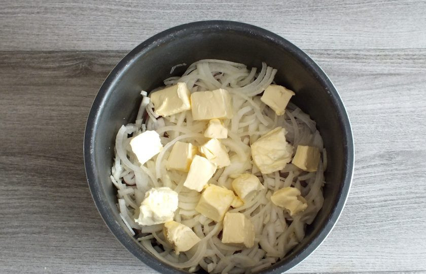 1. Этап. Говядина по-кремлевски в мультиварке: В чашу мультиварки выложите подготовленные мясо и лук. Сверху распределите нарезанное сливочное масло. Добавьте 100 мл. кипятка. Установите чашу в мультиварку. Выставите режим 