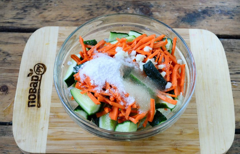 1. Этап. Огурцы по-корейски на зиму (простой рецепт): Смешайте огурцы и морковь в глубокой миске, добавьте сахар, соль, измельченный чеснок, растительное масло и уксус.