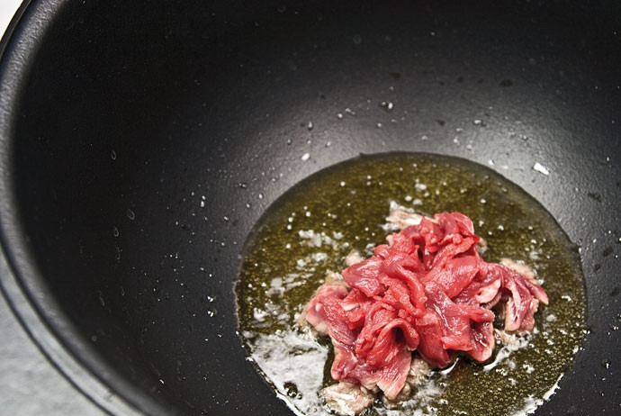 1. Этап. Солянка в казане: 3. На дно казана налейте растительное масло и как следует разогрейте. Выложите туда говядину и немного обжарьте.