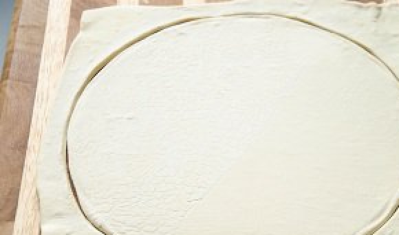 1. Этап. Курник из слоеного теста: За это время слоеное тесто уже должно разморозиться. Раскатываем его до толщины 6 мм, вырезаем круг, кладем на противень.