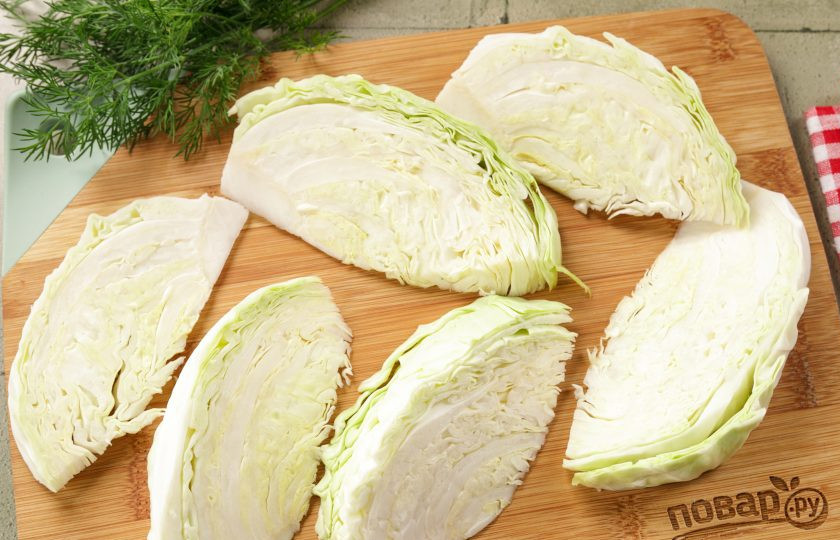 1. Этап. Капуста припущенная: Если у вас целый качан, сначала разрежьте его вдоль пополам. Не забудьте снять верхние листья. Нарежьте по кочерыжке на дольки. У меня получилось шесть частей толщиной 1,5-2 см.