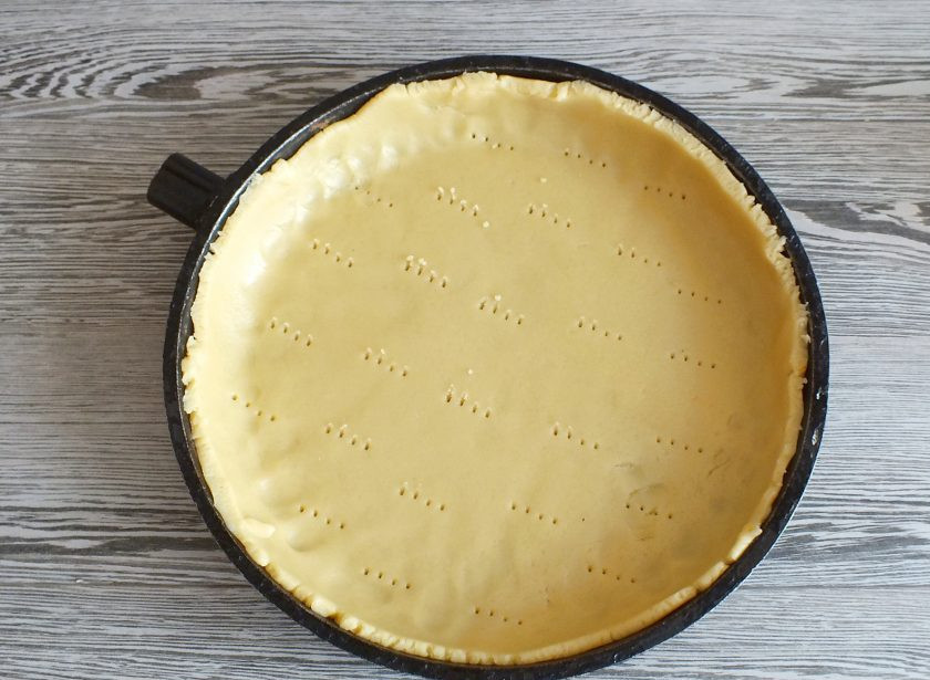 1. Этап. Пирог с творогом и сгущенкой: Сковороду или форму диаметром 26-28 см. смажьте тонким слоем сливочного масла. Переложите пласт в форму. Обрежьте с помощью ножа края, формуя ровные бортики. Донышко проколите вилкой.