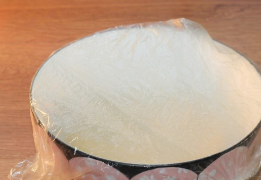 1. Этап. Булочки-трубочки с творогом и повидлом: 5. Небольшими частями вмешиваем в тесто мучную смесь. Замешиваем гладкое, мягкое и не липкое тесто. Смазываем тесто и миску растительным маслом (0,5 ст. л.) и закрываем прозрачным пакетом. Оставляем миску с тестом в холодильнике на ночь.