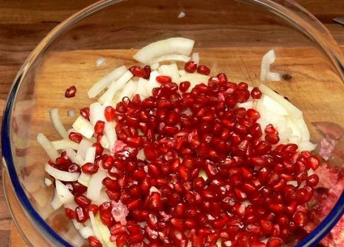 1. Этап. Салат с гранатовыми зернами: Перекладываем лук в салатник, добавим нарезанное тонкими полосками яблоко и очищенные зерна граната.