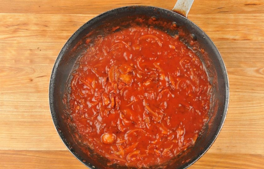 1. Этап. Букатини с ветчиной: 2. В большой сковороде разогрейте масло. Обжарьте в нём половину чеснока с перцем в течение 40 секунд. Затем добавьте лук и немного соли. Готовьте ингредиенты, помешивая, 2 минуту. Потом влейте соус и добавьте большую часть ветчины. Доведите смесь до кипения, а потом тушите 8 минут на небольшом огне.